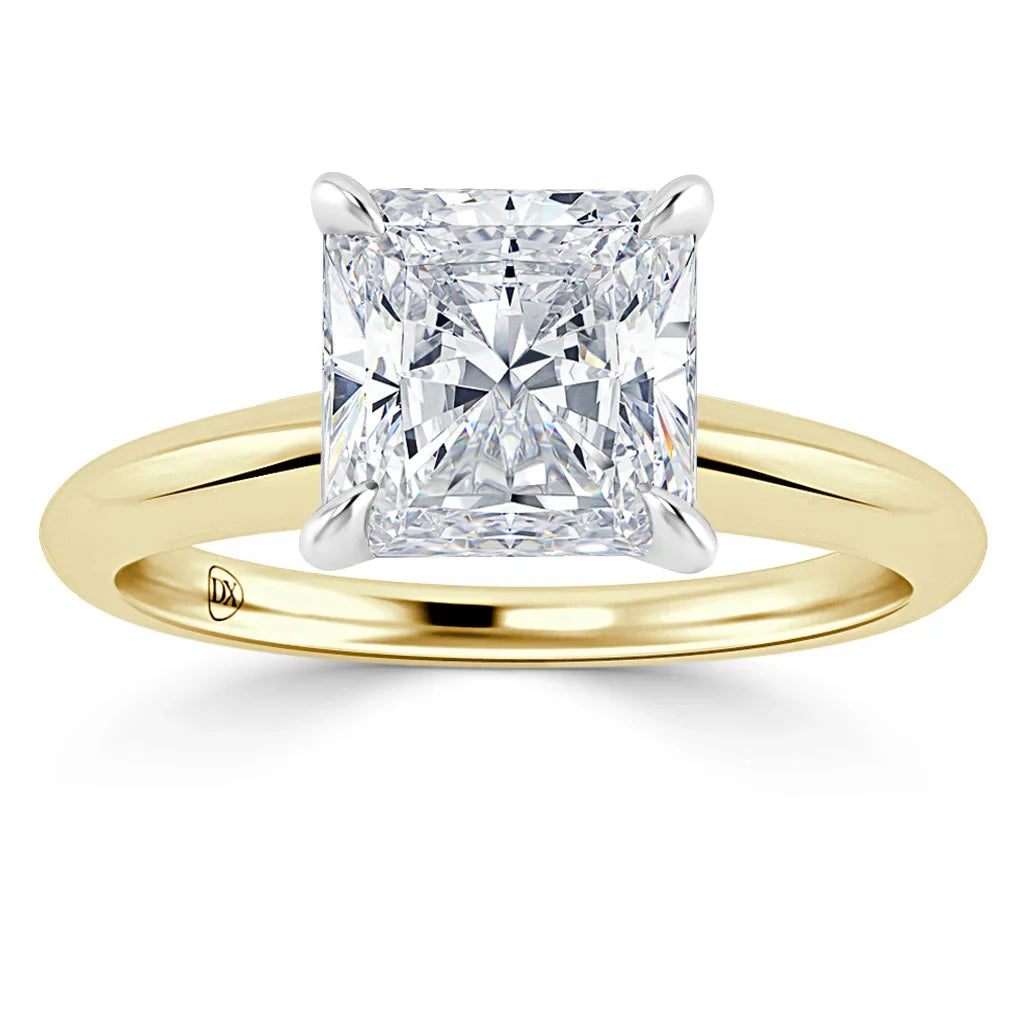 Gold band ring with a large square-cut diamond in a four-prong white gold setting, shown on a white background.