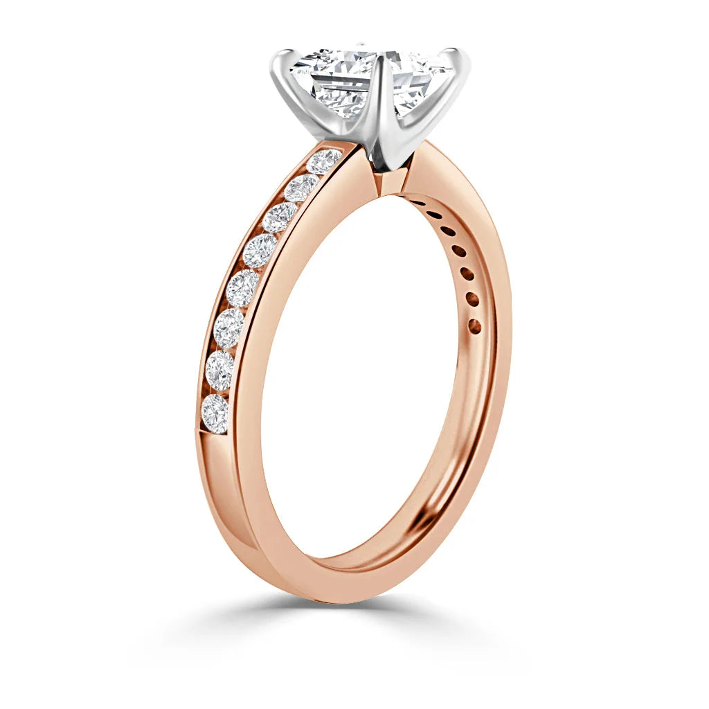 A rose gold ring with round diamonds set along the band and a large solitaire diamond in a prong setting.