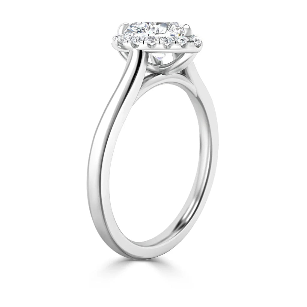 Side view of a white gold diamond engagement ring with a round center stone and a halo of smaller diamonds.