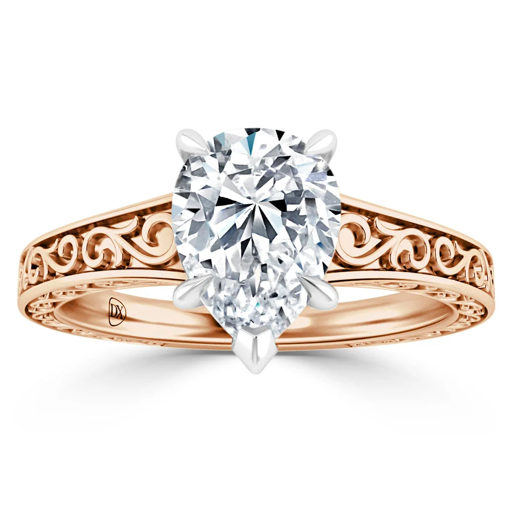 A rose gold ring with ornate scrollwork and a large oval diamond in a four-prong white gold setting.