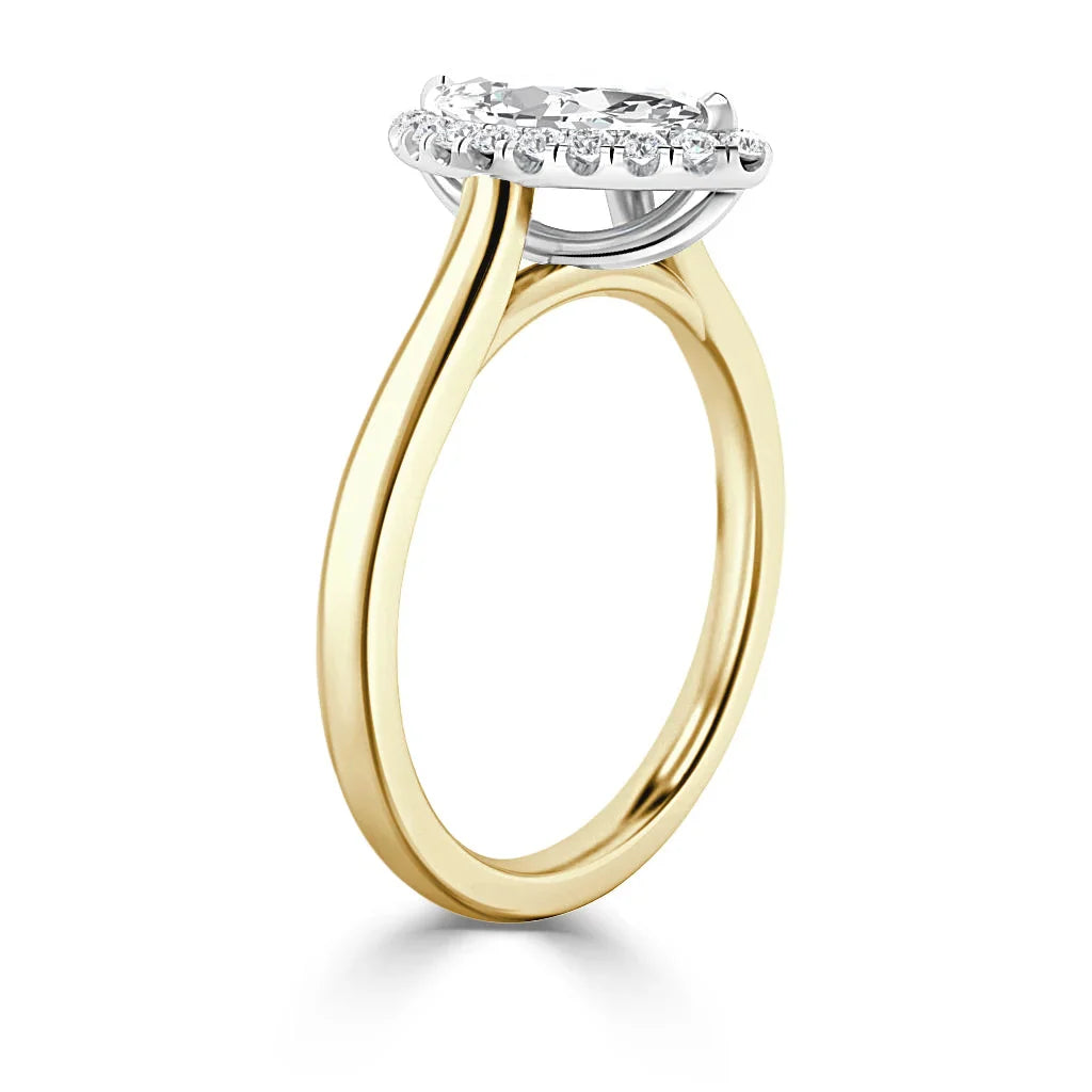 A gold ring with a round diamond halo setting and a thin, smooth band shown from a side angle.