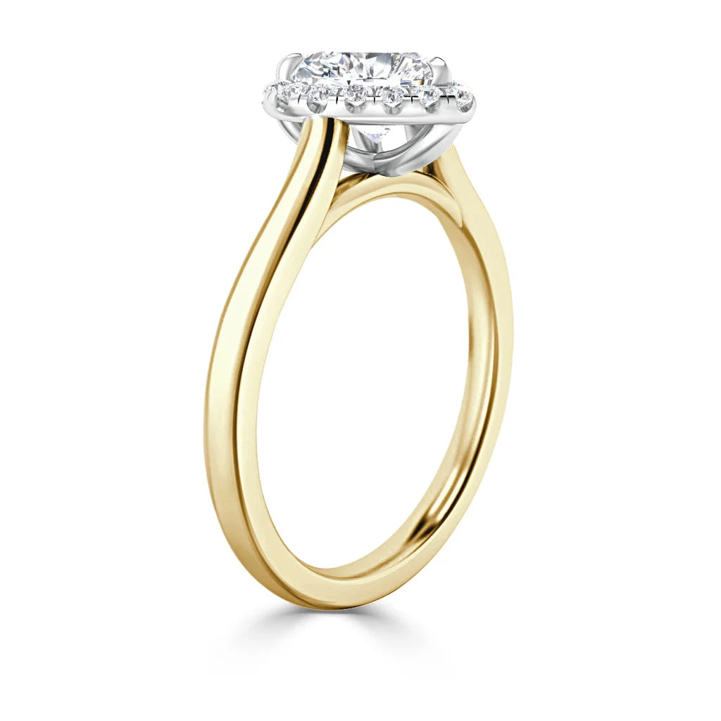 Gold engagement ring with a round diamond halo setting, viewed from the side on a white background.