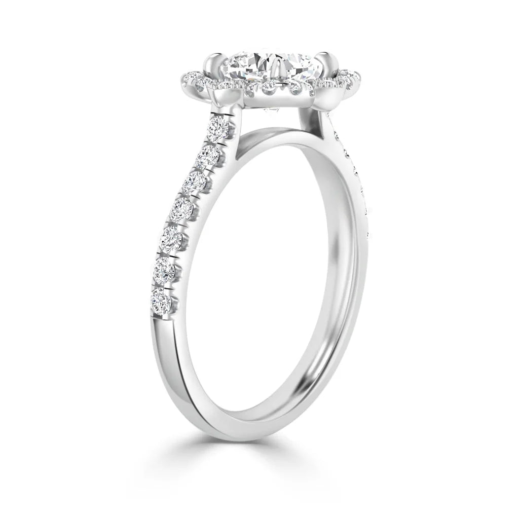 A white gold ring with a round center diamond and smaller diamonds along the band in a raised setting.