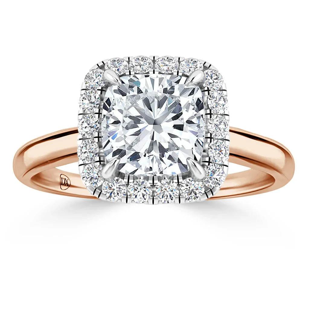Rose gold ring with a cushion-cut diamond center, surrounded by a double halo of smaller diamonds.
