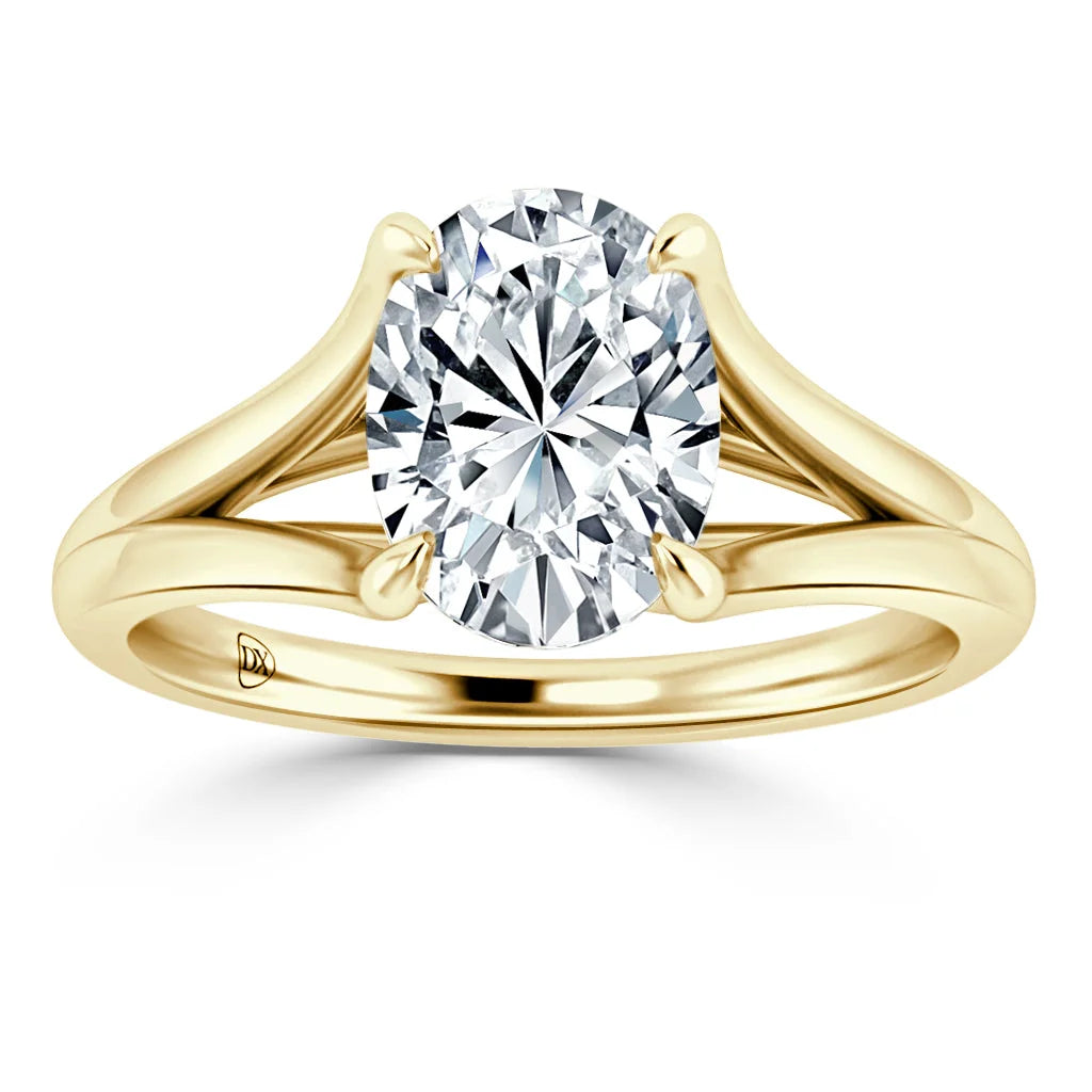 Gold ring with a split shank band and a large, round-cut diamond solitaire set in a four-prong setting.