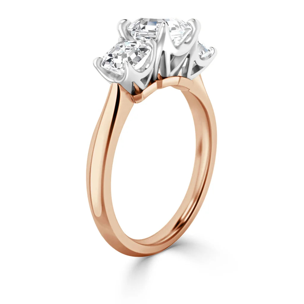 A rose gold ring with three large, clear diamonds in a white prong setting, viewed from the side.