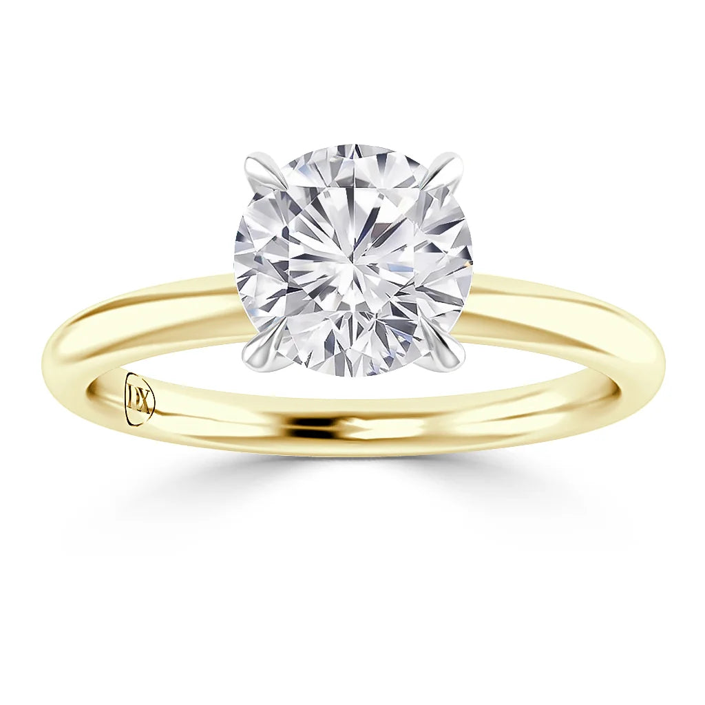 A gold band solitaire ring with a large round diamond set in a four-prong white gold setting.