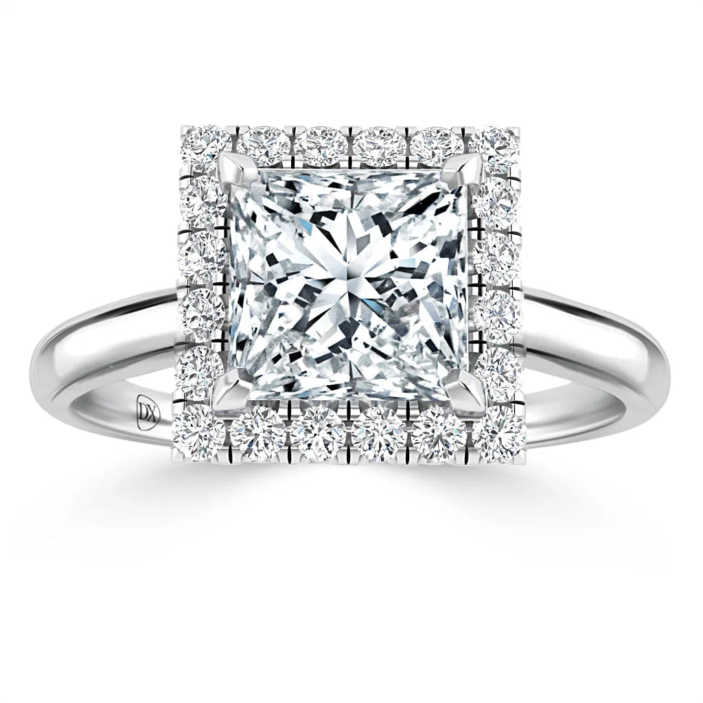 A square-cut diamond ring with a double halo of smaller diamonds on a simple silver band.