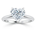 Platinum ring with a large, heart-shaped diamond solitaire on a simple polished band, shown on a white background.