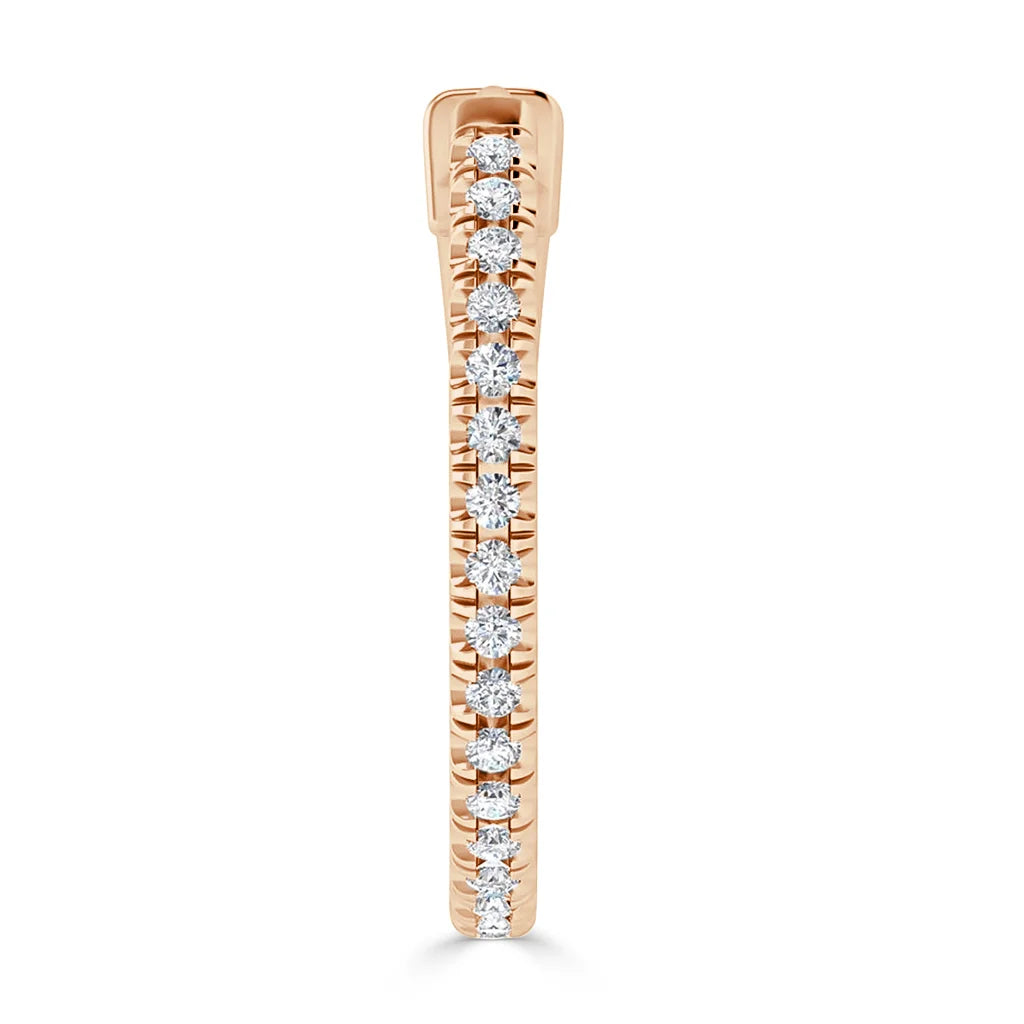 Rose gold ring with a row of small round diamonds set along the top half, shown from a side angle.