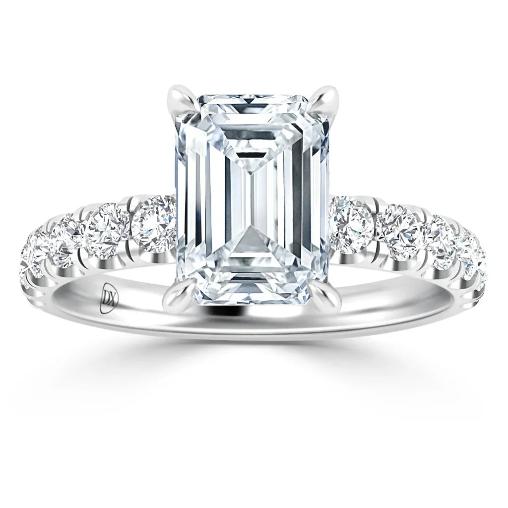 Emerald-cut diamond ring with a pavé diamond band set in white metal, shown against a white background.