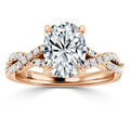 Rose gold ring with an oval diamond center stone and a twisted, diamond-accented band.