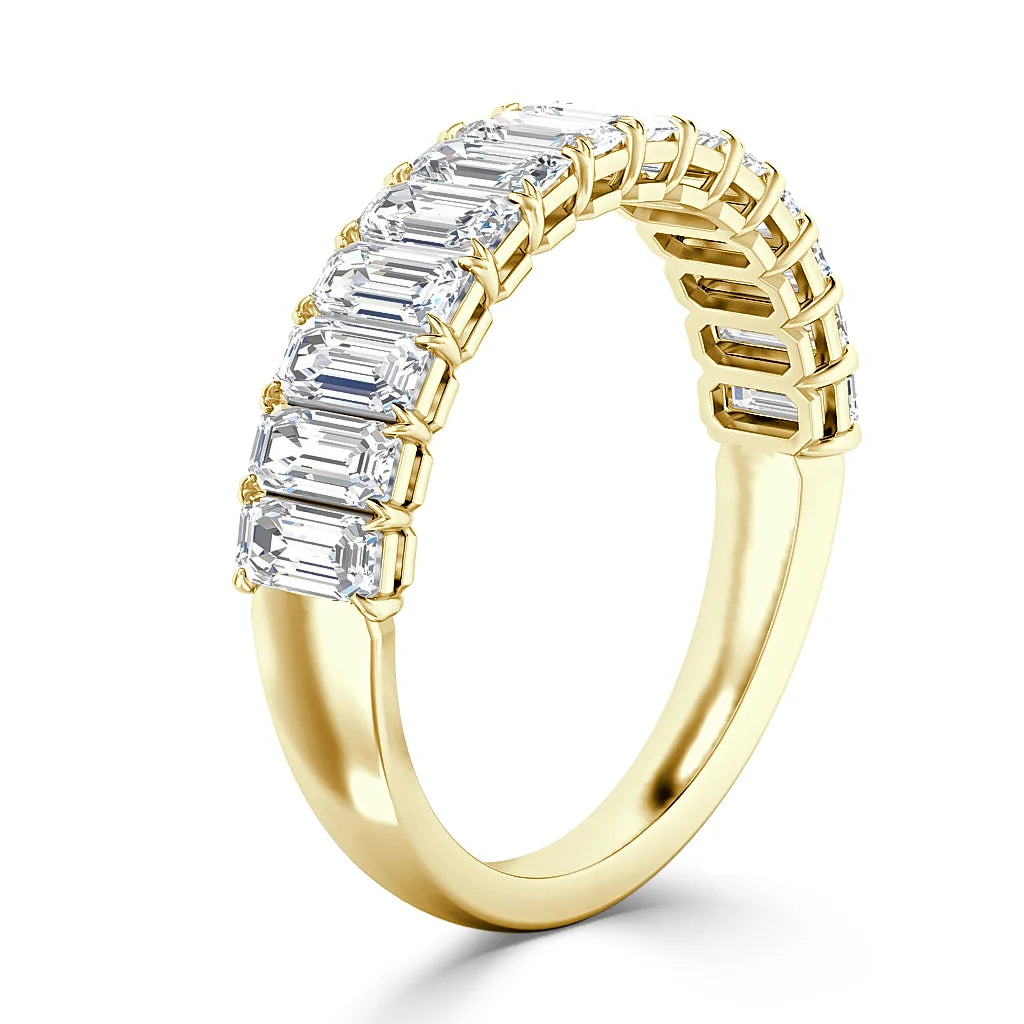 Gold ring featuring a row of rectangular emerald-cut diamonds set across the top half of the band.