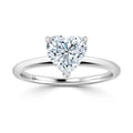 A silver ring with a heart-shaped diamond solitaire set on a thin, plain band against a white background.
