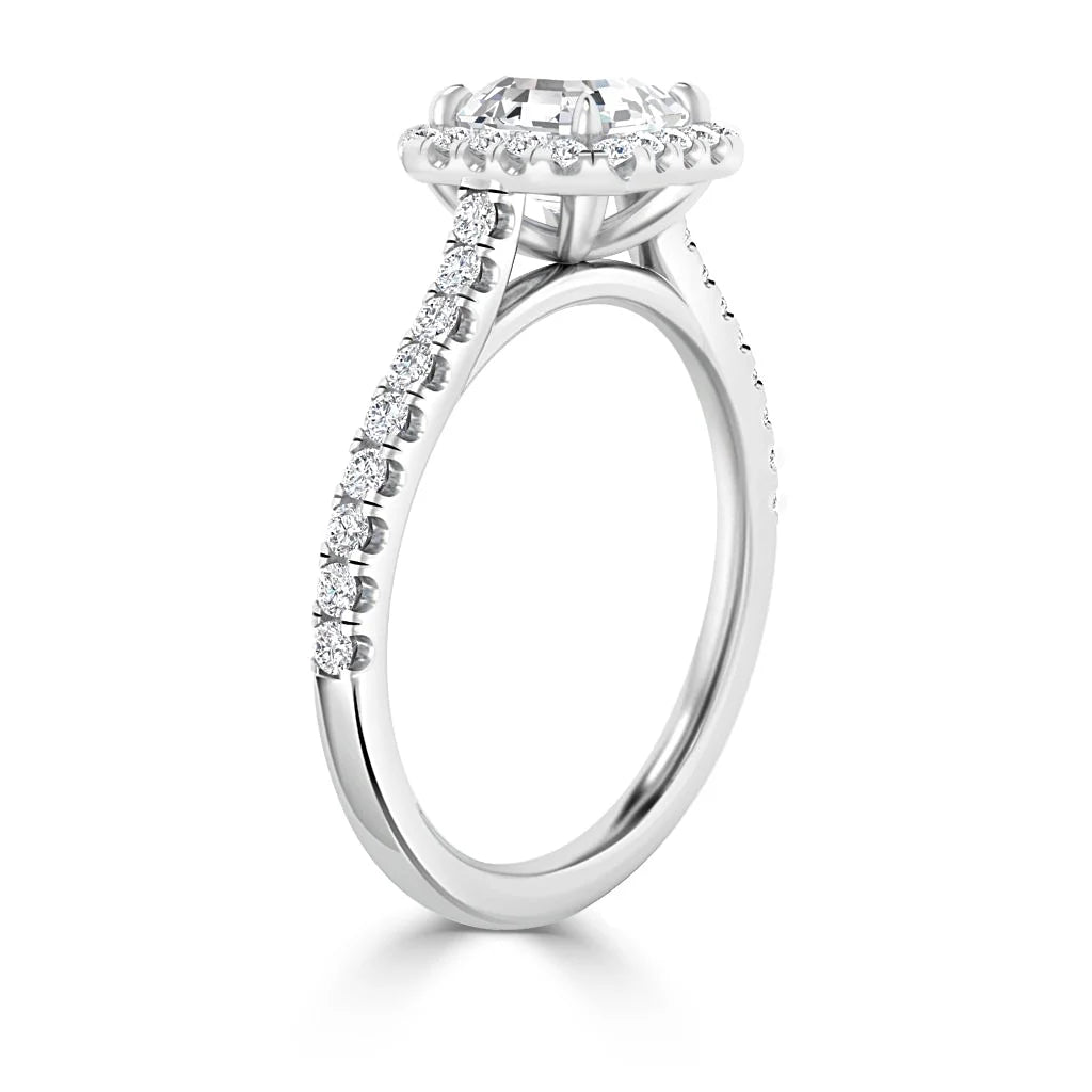 White gold ring with a round halo setting and pavé diamonds along the band, viewed from the side.