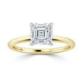 A gold ring with an asscher-cut diamond solitaire set in a simple, elegant setting on a white background.