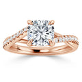 A rose gold ring with a square cushion-cut diamond center and a split band set with small round diamonds.