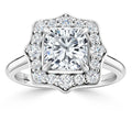 A square-cut diamond ring with a scalloped halo of small round diamonds on a sleek silver band.