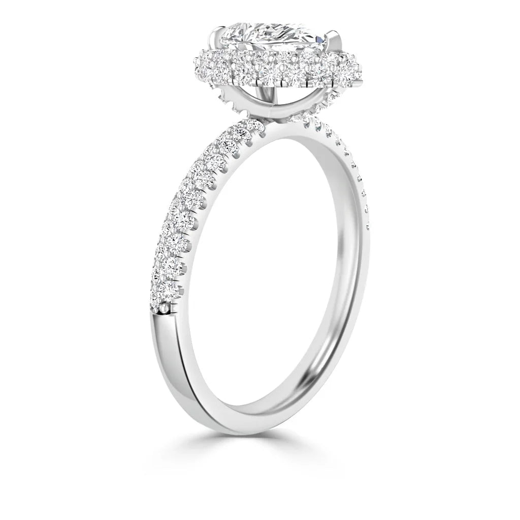 A white gold oval diamond ring with a halo and a band adorned with small round diamonds.