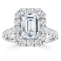 Emerald-cut diamond ring with a halo of round diamonds on a platinum band adorned with more diamonds.
