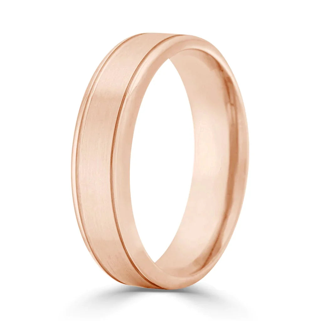 A rose gold wedding band with a matte finish and a single polished groove around the center.