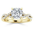 Gold ring with a large cushion-cut diamond and a twisted band set with small round diamonds.