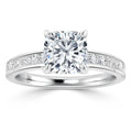 Platinum ring with a cushion-cut diamond center stone and small diamonds set along the band.