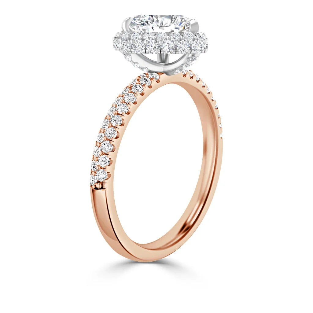 Rose gold ring with a round diamond halo setting and small diamonds along the thin band, shown in profile view.