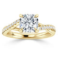 Yellow gold ring with cushion-cut diamond center and pavé-set diamonds on split shank band.