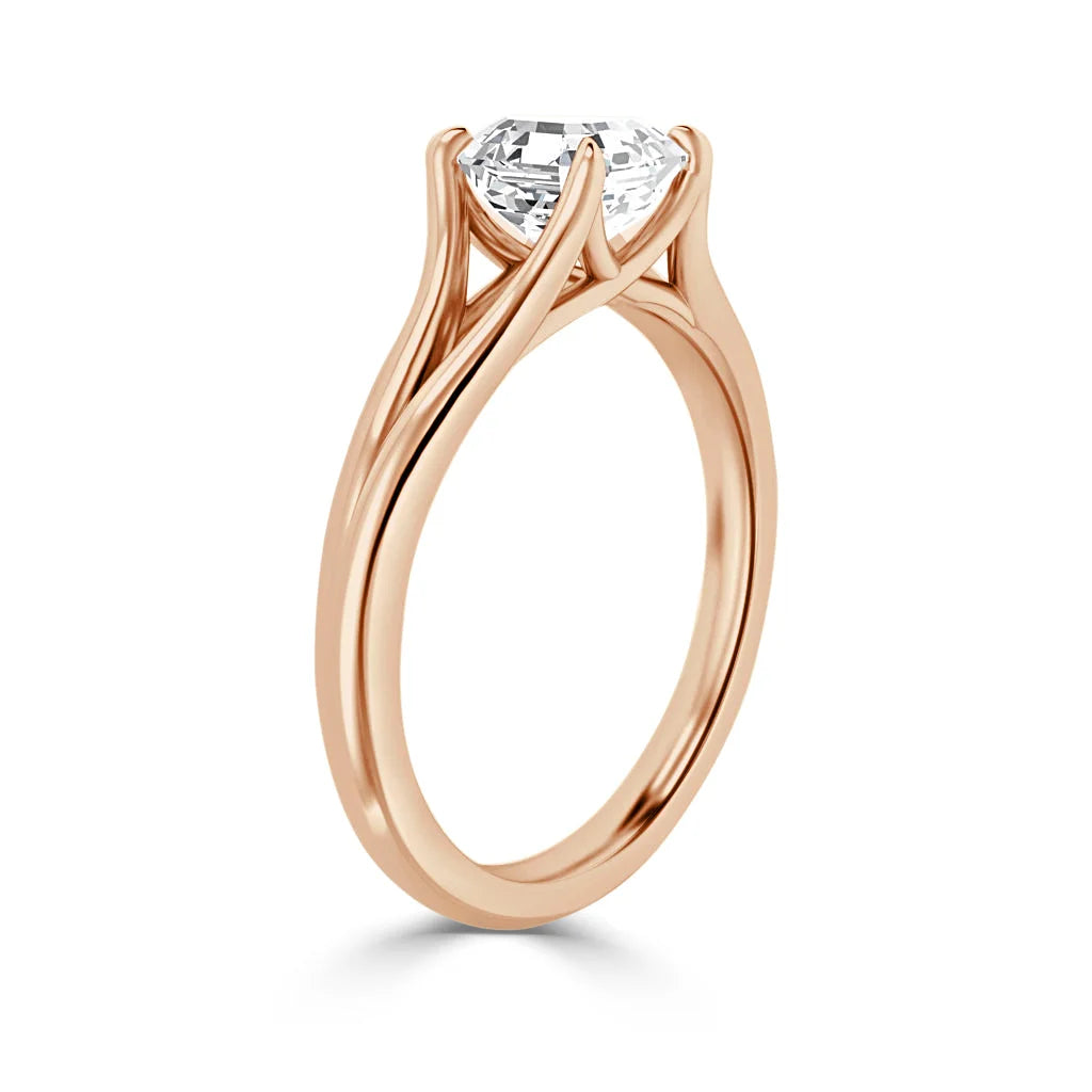 A rose gold engagement ring with a round solitaire diamond in a unique four-prong setting, viewed from the side.
