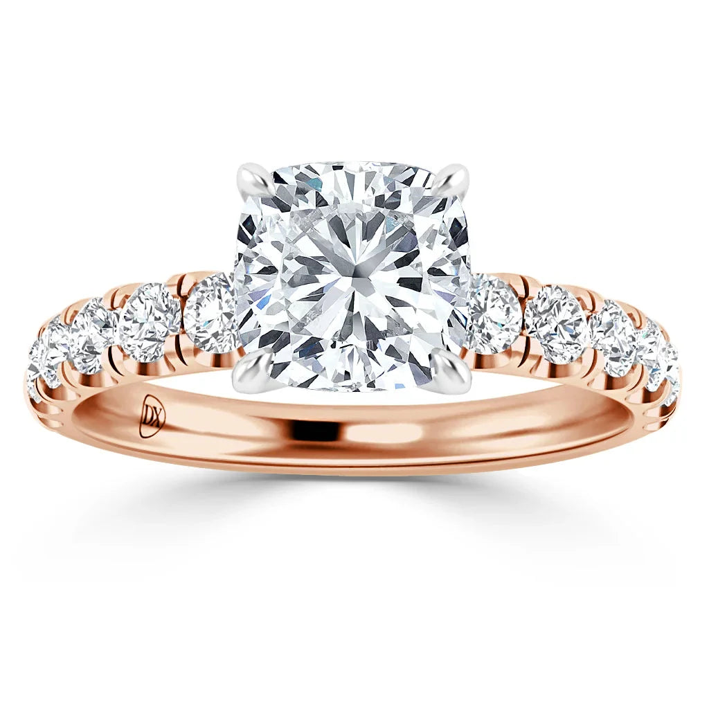 A rose gold ring with a cushion-cut diamond center stone and smaller diamonds along the band.