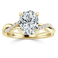 Gold ring with an oval diamond center stone, twisted band, and small accent diamonds along one side.