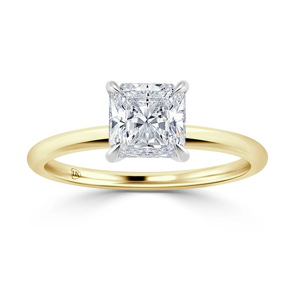 A gold band ring with a square-cut diamond in a four-prong setting, shown on a white background.