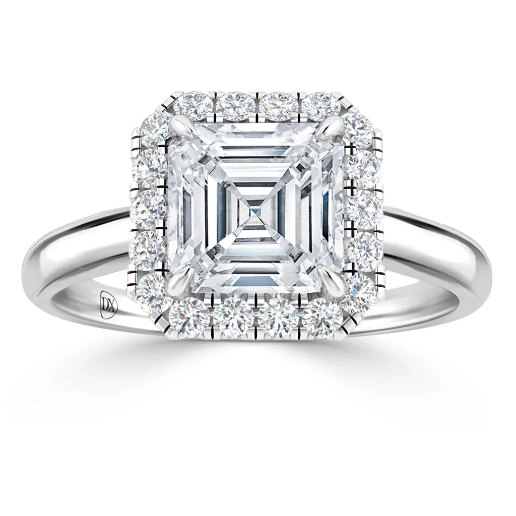 Square-cut diamond ring with a double halo of smaller round diamonds on a plain silver band.