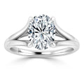 A solitaire diamond ring with a split shank platinum band and an oval-cut diamond in a four-prong setting.