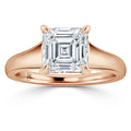 Rose gold ring with a large, square-cut diamond held by four prongs, displayed on a white background.