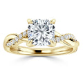 Gold ring with a large cushion-cut diamond center and a twisted band accented with small round diamonds.
