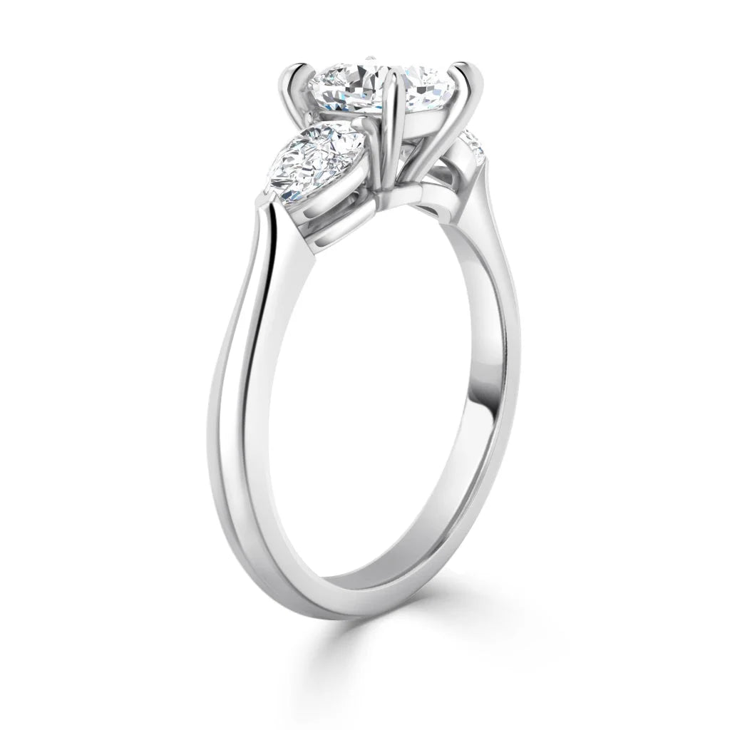 A white gold ring with three round diamonds in prong settings, viewed from an angled side perspective.