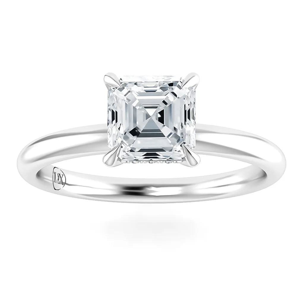 A solitaire ring with an Asscher-cut diamond set on a simple, polished white metal band.