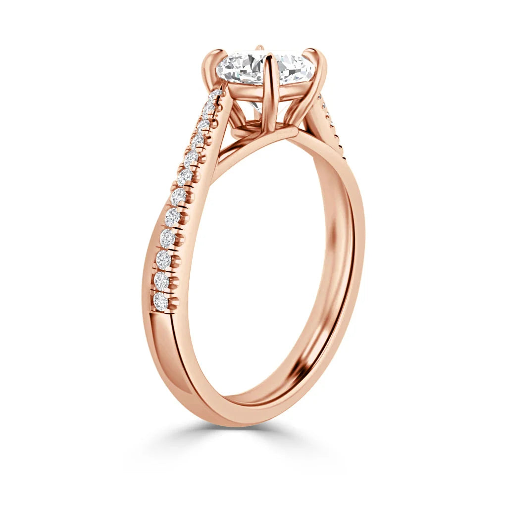 Rose gold ring with a round solitaire diamond and small diamonds set along the band in a row.