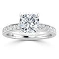 A platinum ring with a large cushion-cut diamond center and small diamonds set along the band.