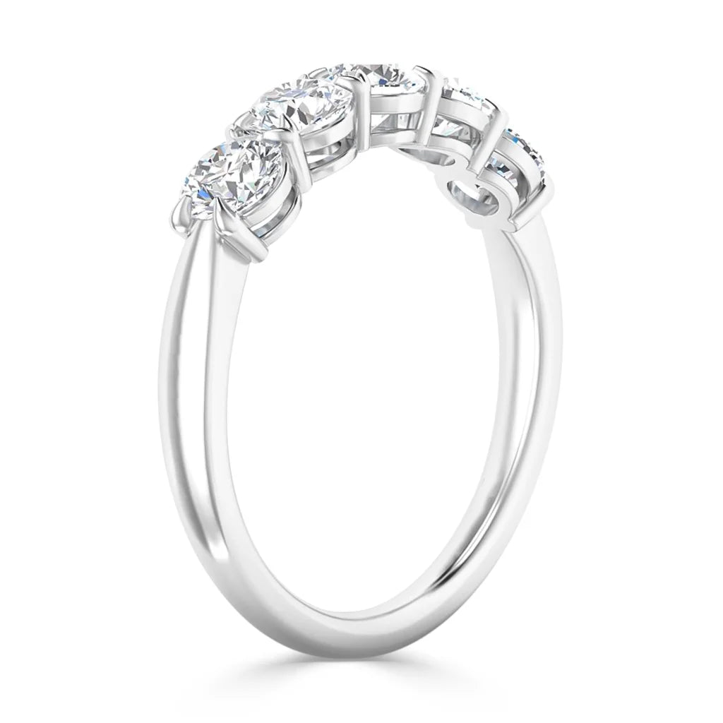 A white gold ring with three round diamonds set in prongs, shown from a side angle on a white background.