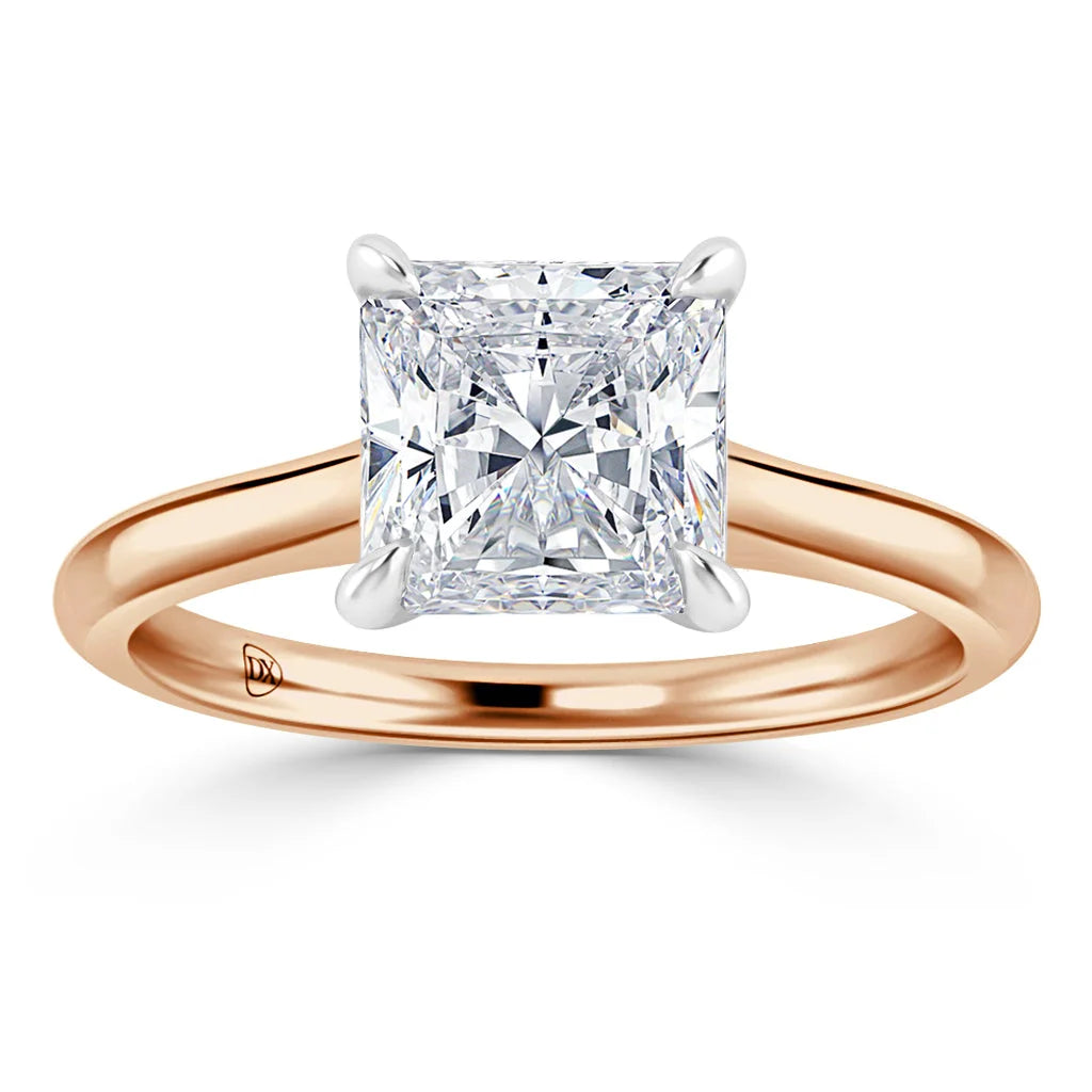 A princess-cut diamond solitaire ring with a rose gold band and four prongs securing the stone.