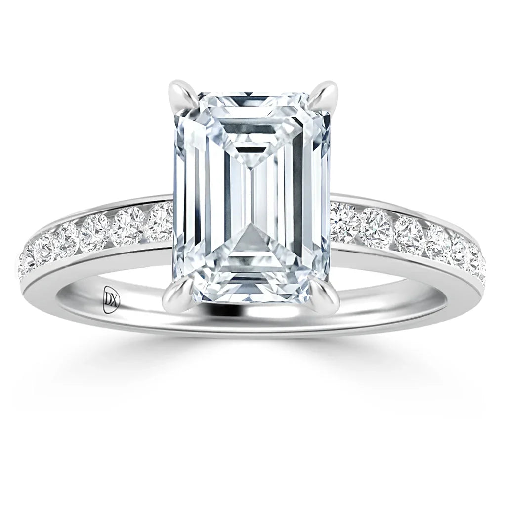 A platinum ring with a large emerald-cut diamond center and smaller diamonds set along the band.