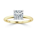 A gold band ring with a large, square-cut diamond set in a four-prong white gold setting.