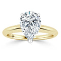 A gold ring with a large pear-shaped diamond solitaire set in a simple, polished band.