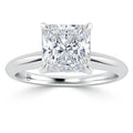 A solitaire ring with a large princess-cut diamond set on a simple, polished silver band.