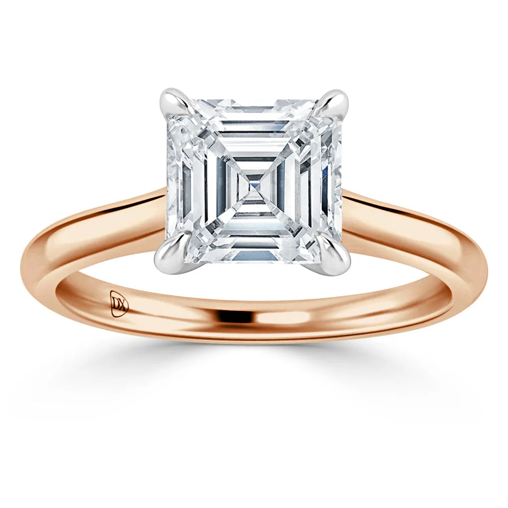 Solitaire ring with an Asscher-cut diamond set on a simple yellow gold band against a white background.