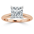 A rose gold ring with a large, square-cut diamond set in a four-prong solitaire setting.