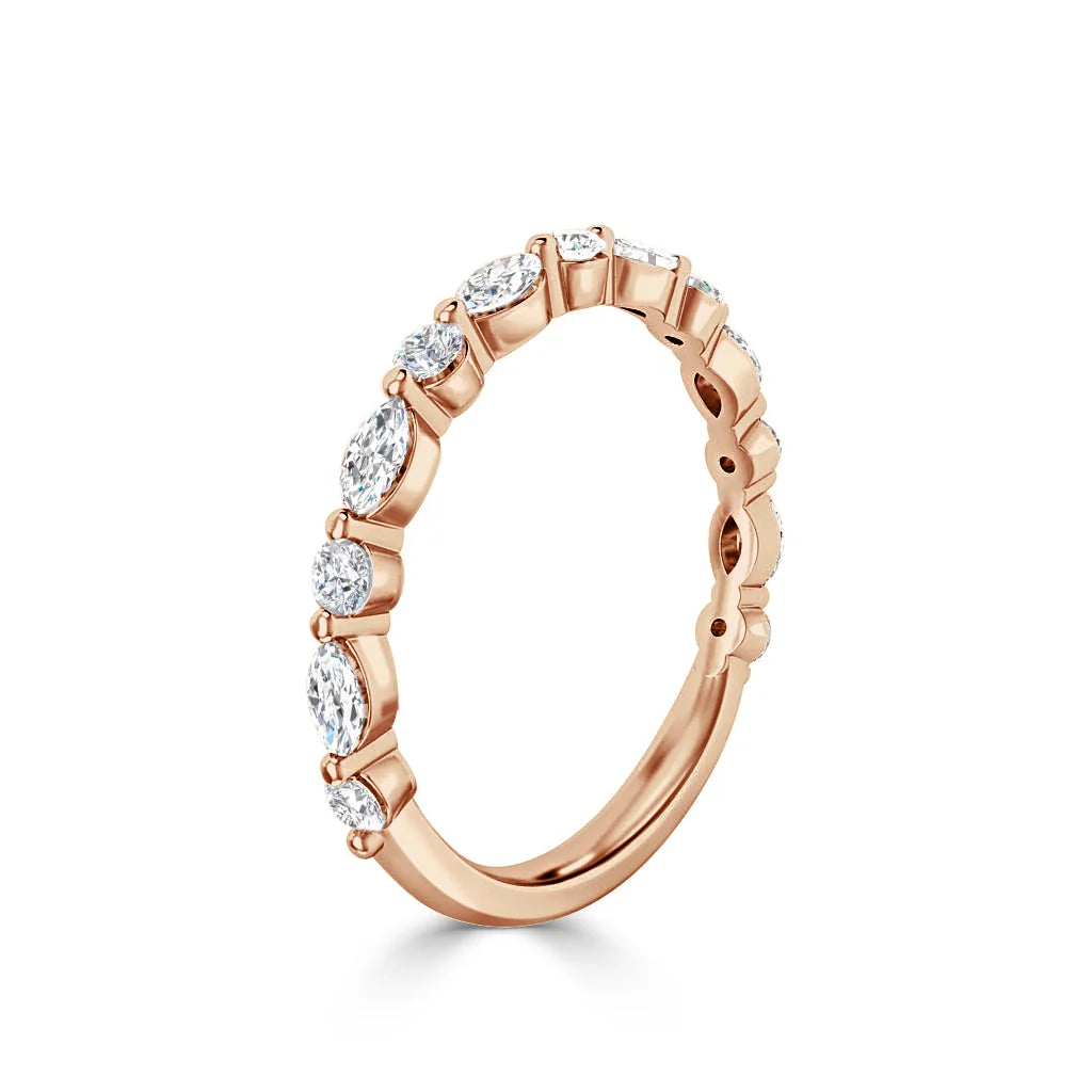 Rose gold ring with alternating marquise and round diamonds set along half of the band, on a white background.